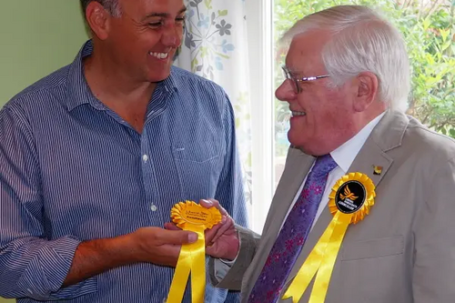 Cllr Ron Tindall (right) handing over a candidate rosette to Adrian England (left)